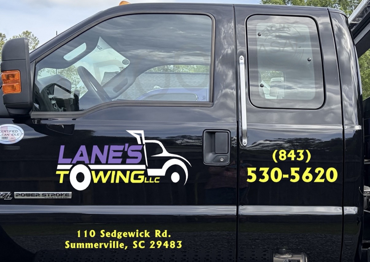 The door of a black Lane's Towing truck with our logo, phone number (843) 530-5620 and address