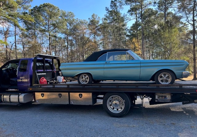 A light blue 1960s convertible loaded on our flatbed